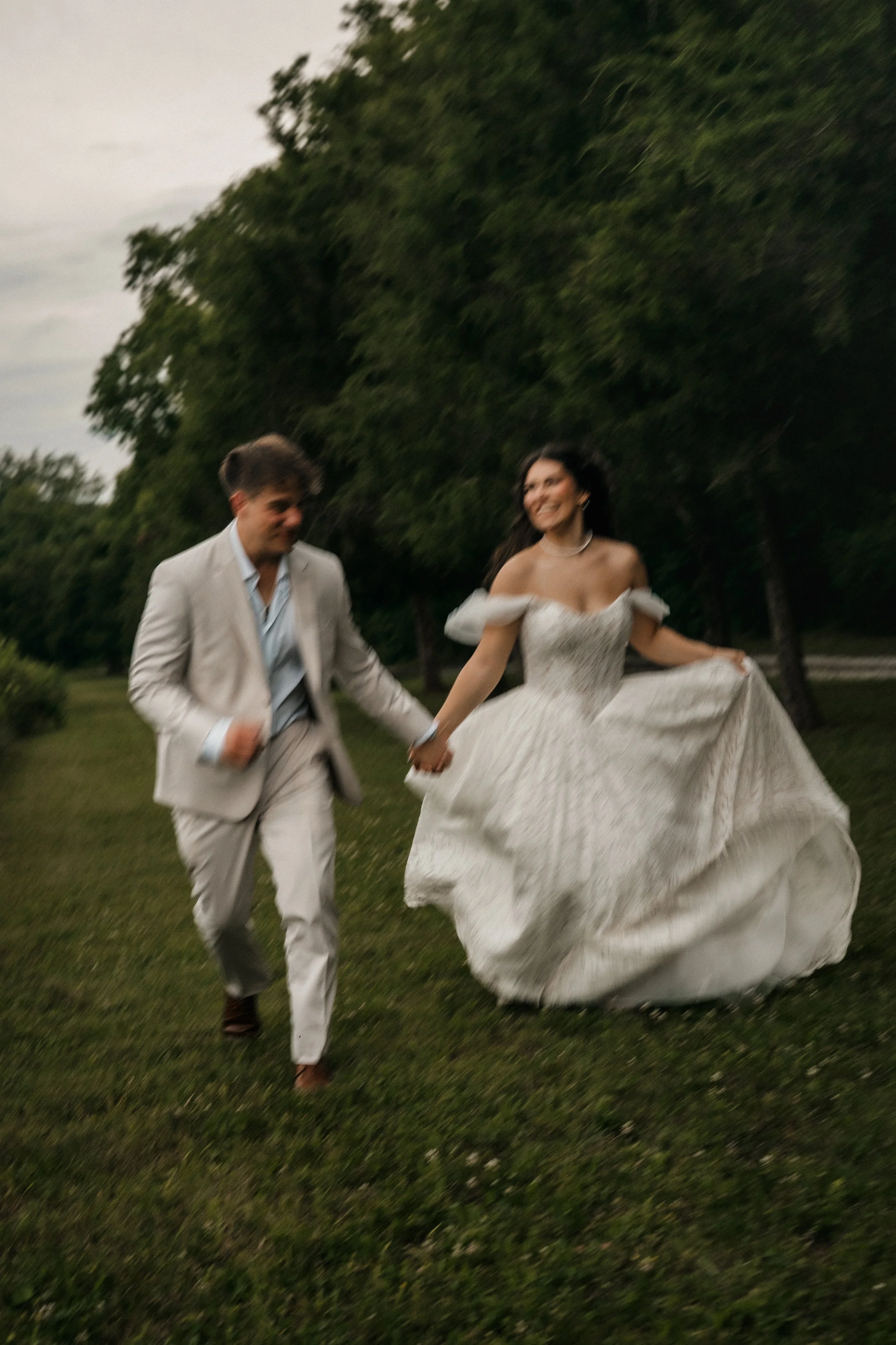 Newlyweds running together through a field