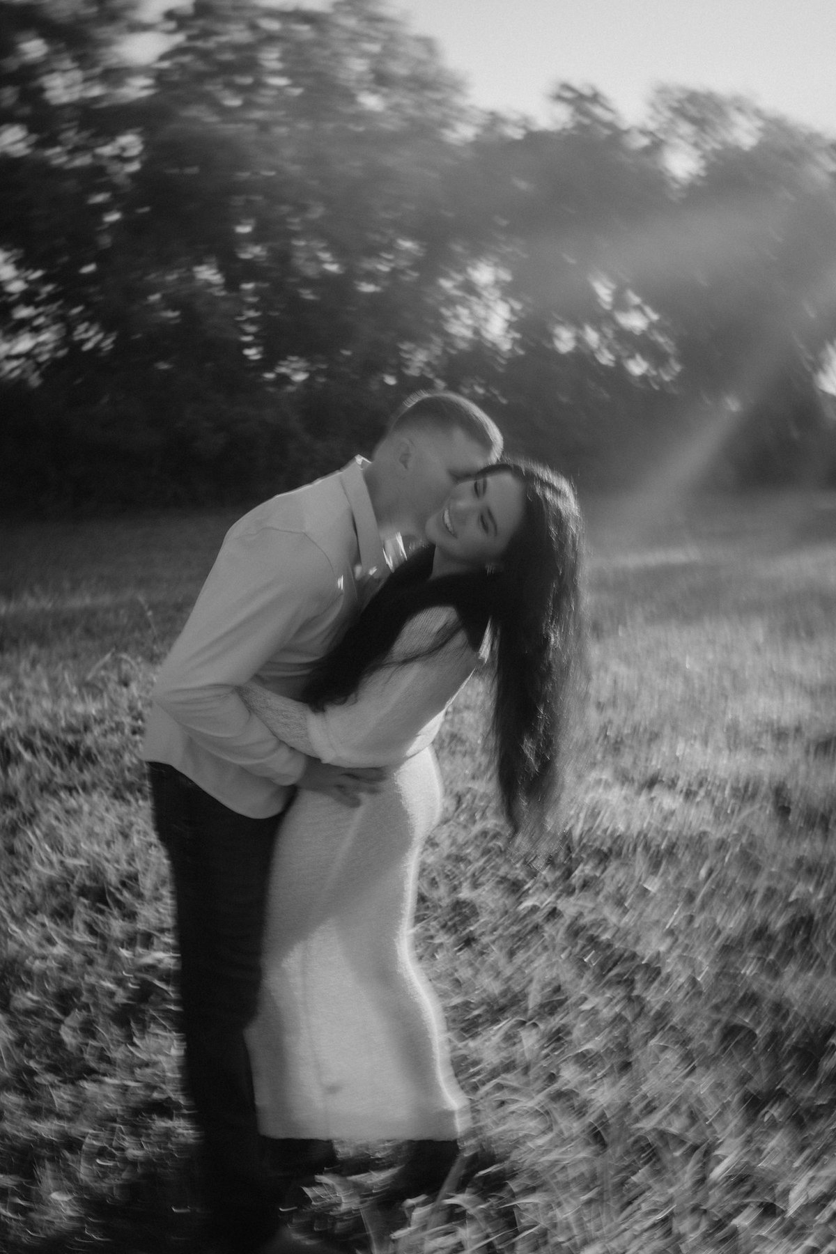 Vanessa and Fletcher in a sunlit field, photographed in black and white by LY Photography Co
