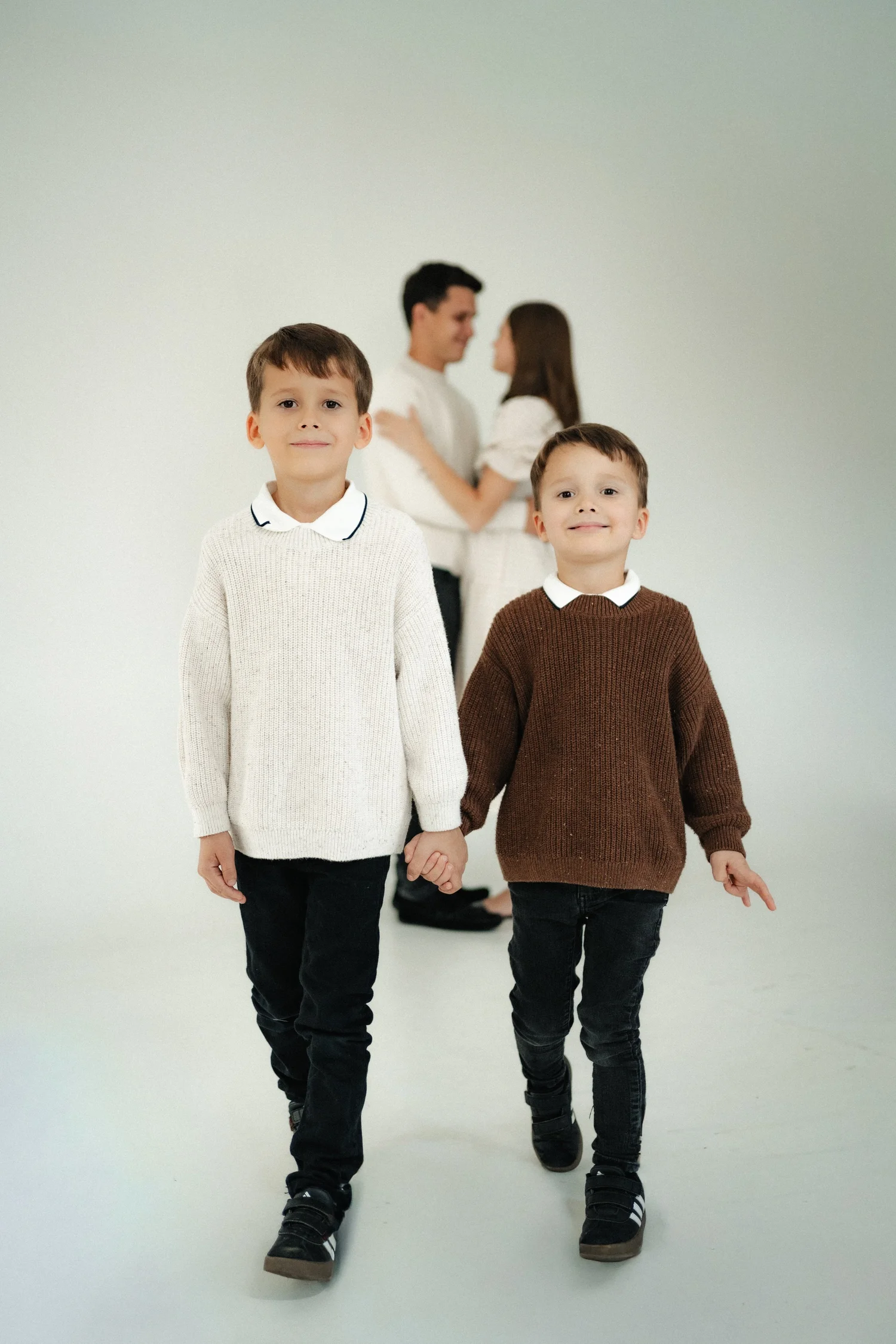 Two brothers walking hand in hand during a family studio session