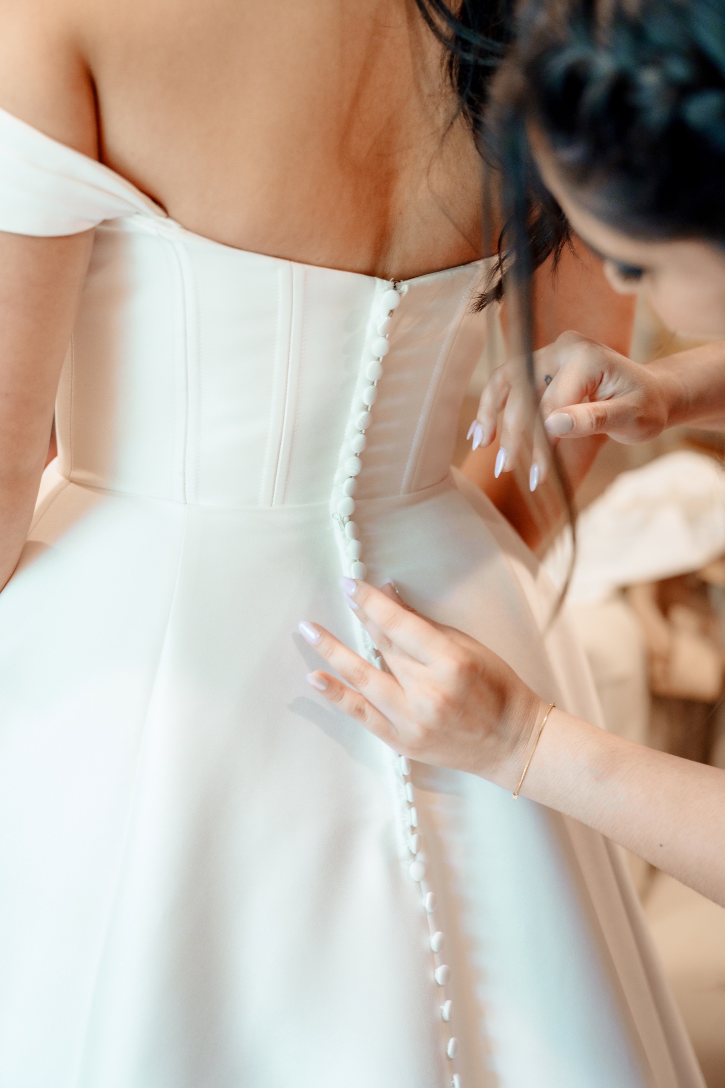 Carleigh having her wedding dress buttoned