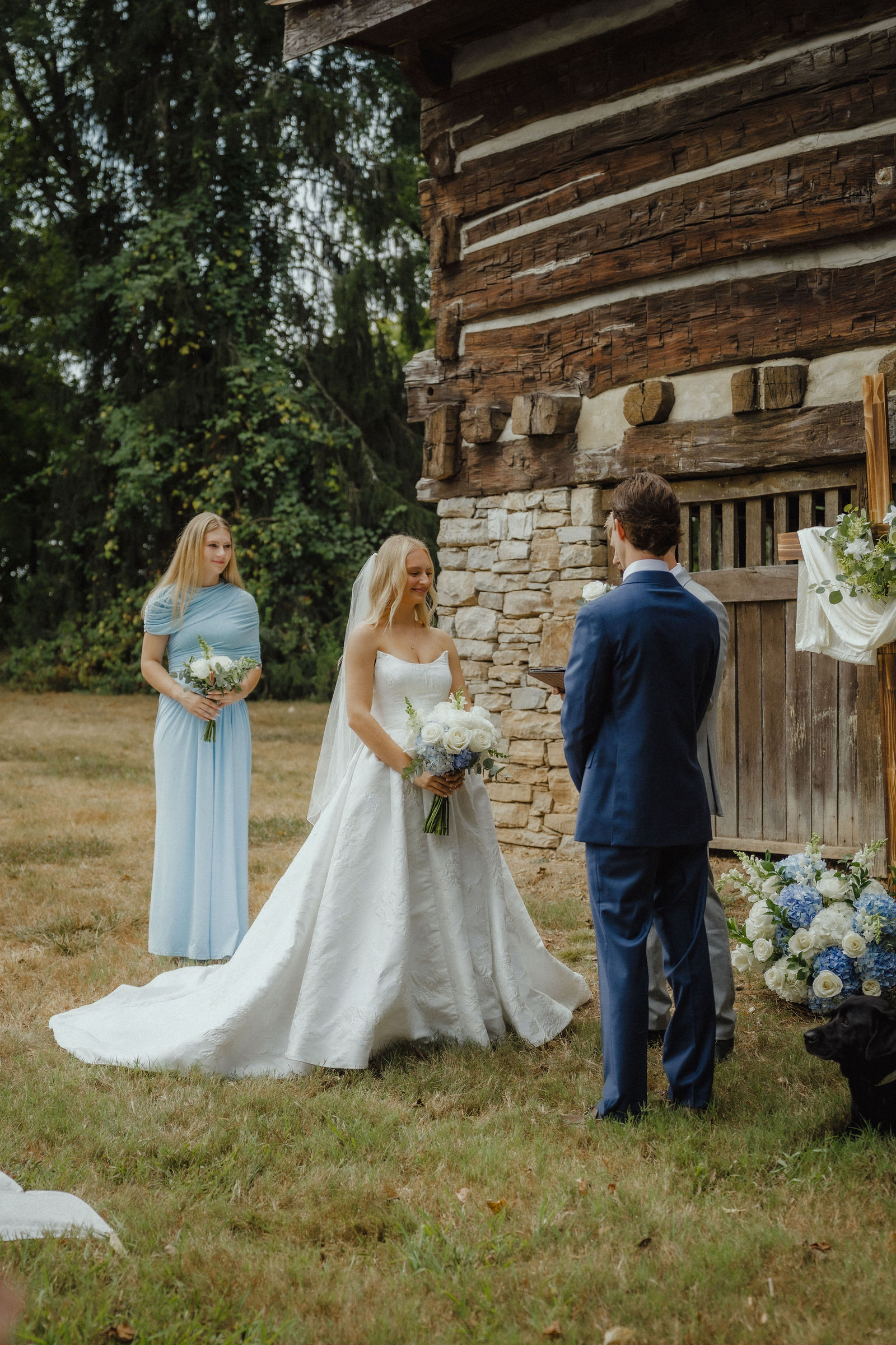 Denalyn and John at the altar in front of the 1830 log wall and stone chimney