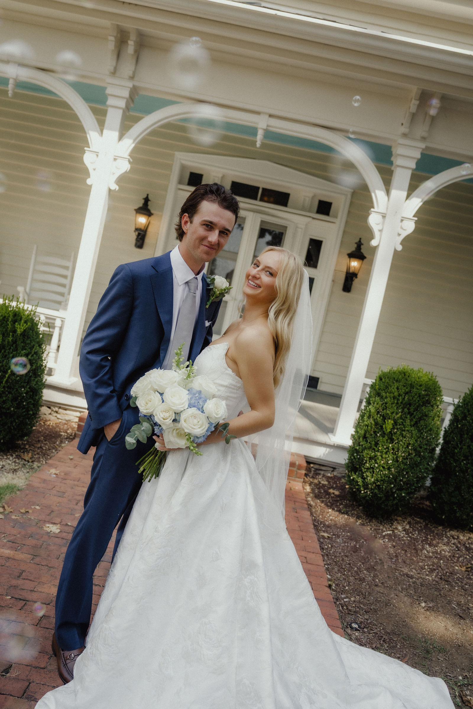 The two of them on the brick walk in front of the porch with bubbles in the air