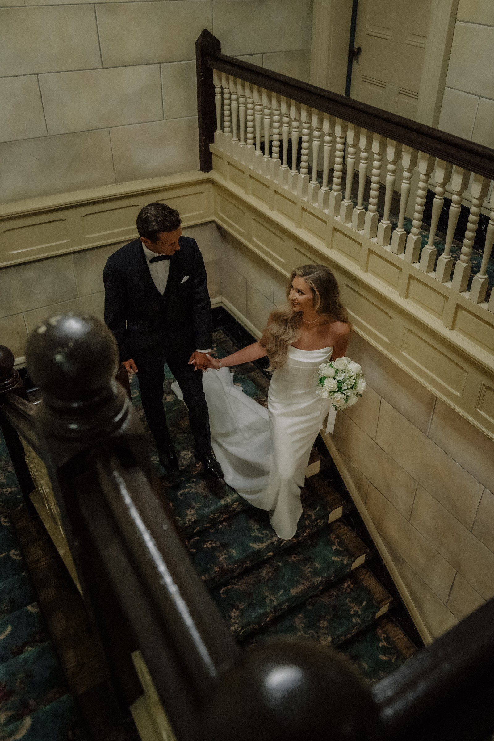 Maddie and Brandon on the staircase, hand in hand