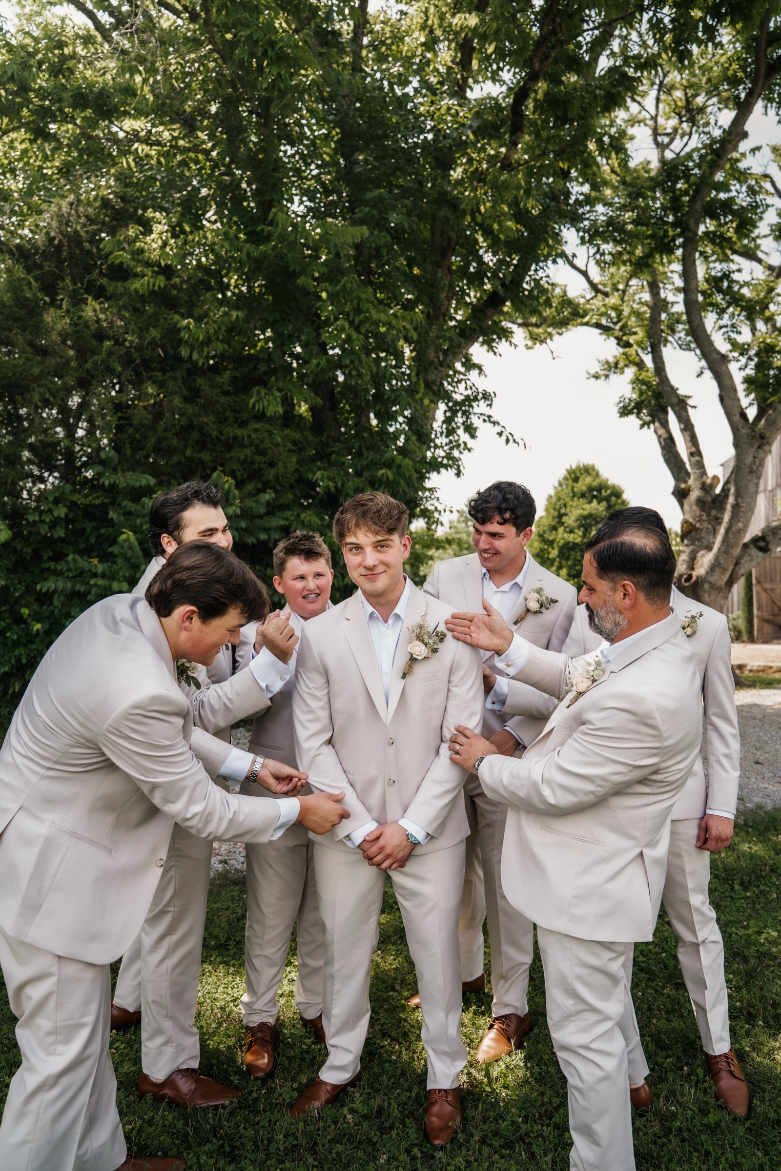 Jack laughing with his groomsmen, all in cream suits