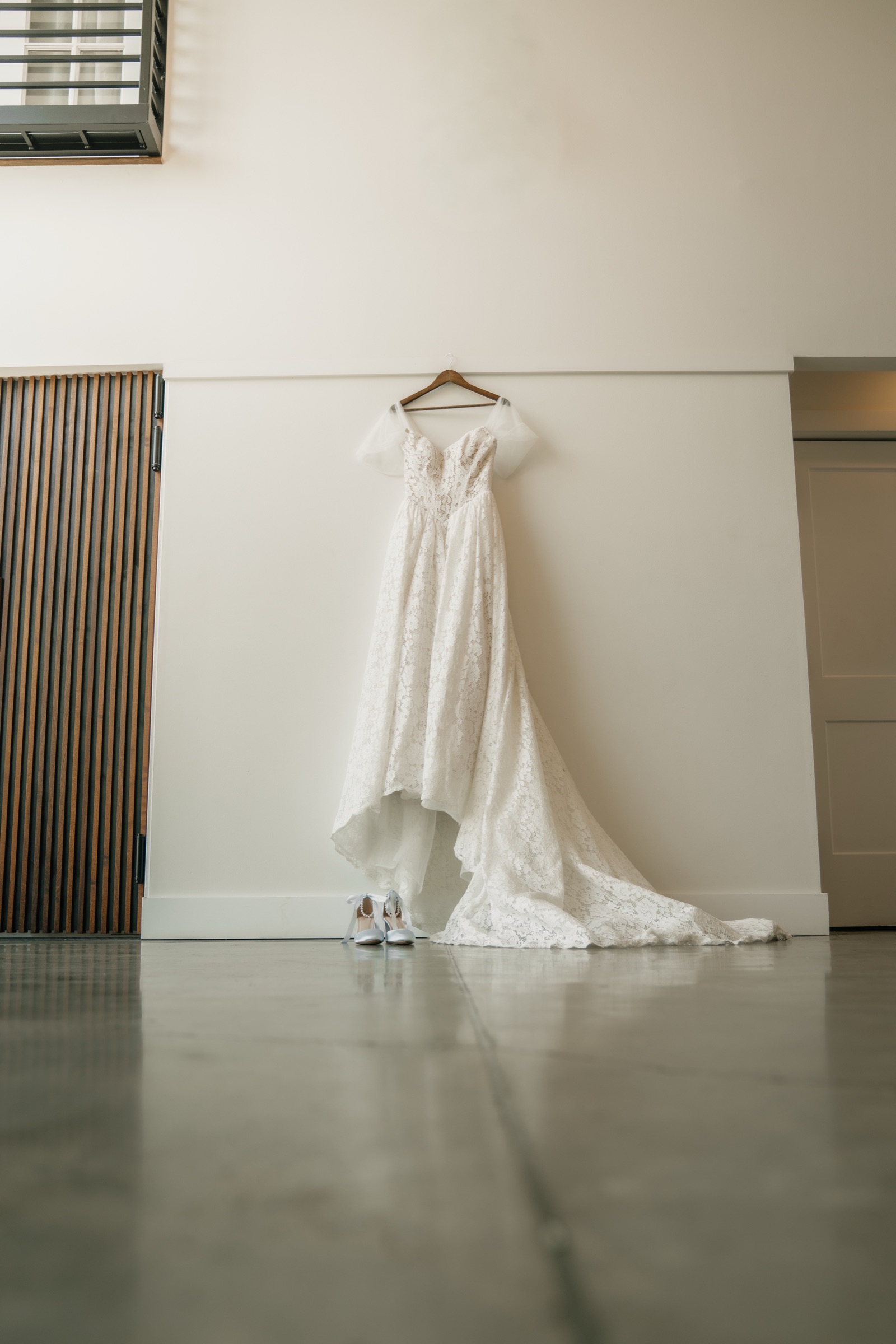 Presley’s lace wedding dress hanging with her shoes waiting beneath it