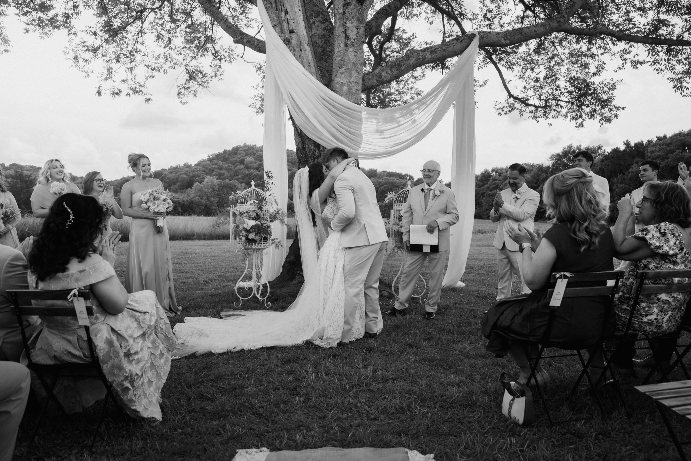 Presley and Jack’s first kiss beneath the draped oak as their guests applaud