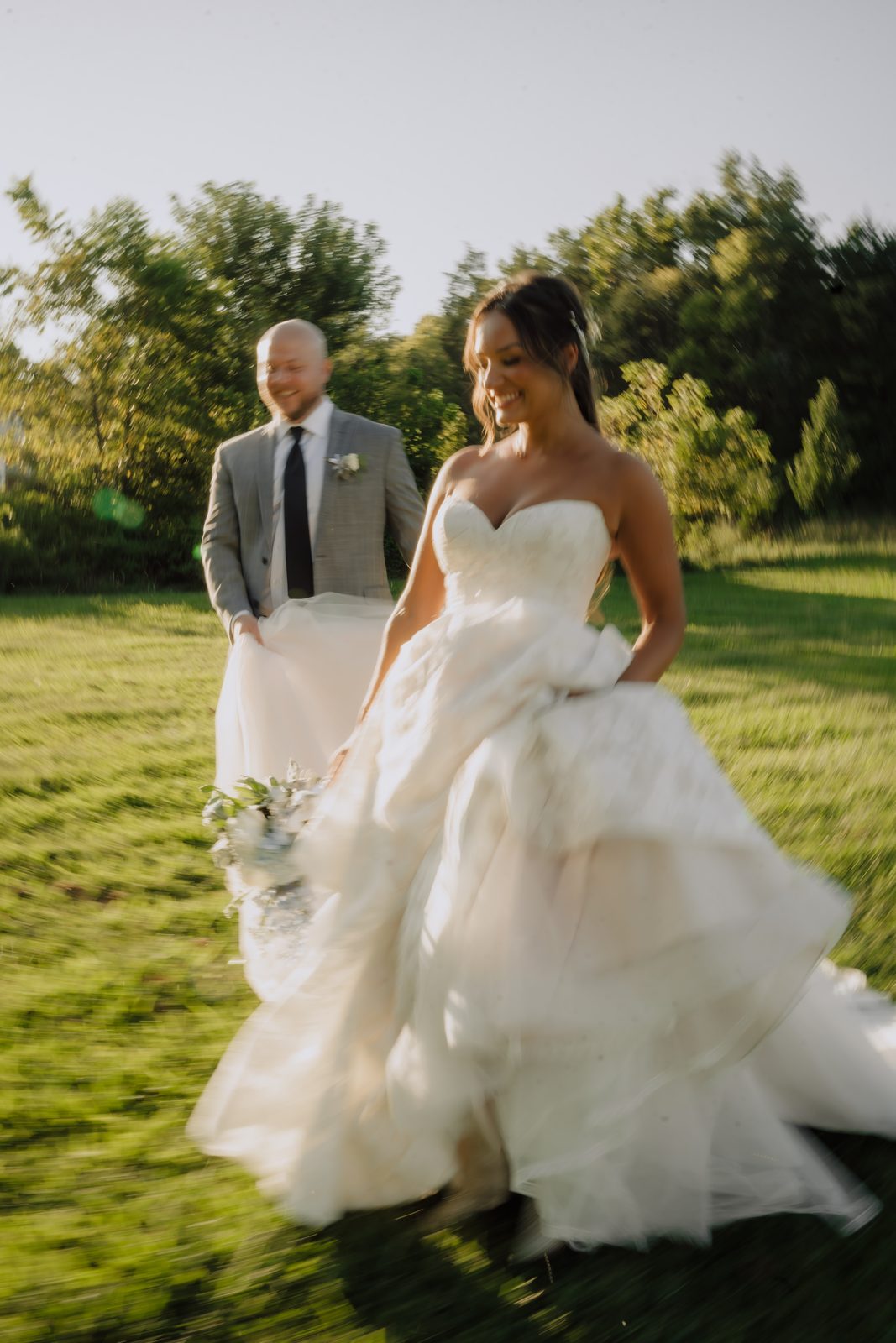 A couple walking across the open lawn at Drakewood Farm in Goodlettsville, Tennessee, in late golden-hour light